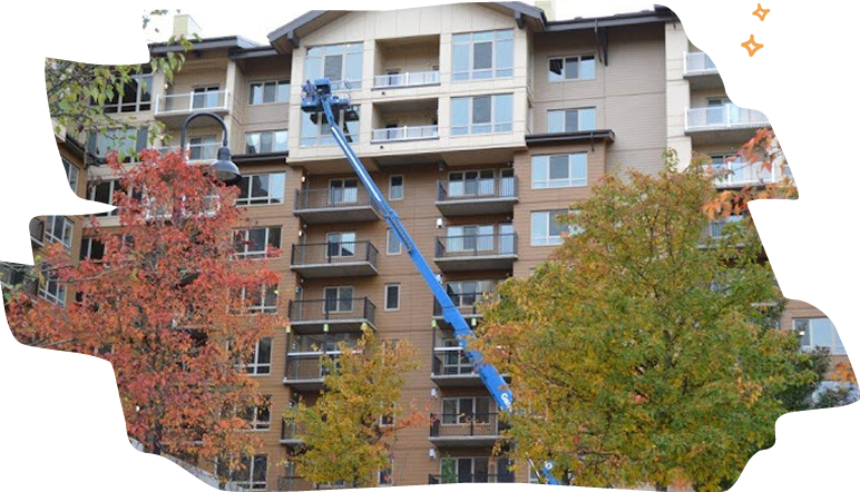 window cleaners in a crane cleaning windows of a multi-story building