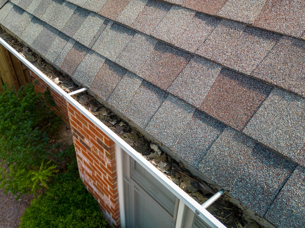 leaves and debris clogging a residential gutter system